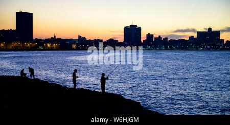 Silhouettes de pêcheurs le long du Malecon avec une silhouette skyline at Dusk, à La Havane, Cuba Banque D'Images
