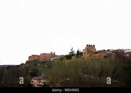 Château de Sigüenza sur sa colline au-dessus de la ville et des arbres sous un ciel pâle avec espace de copie, Guadalajara, Espagne Banque D'Images