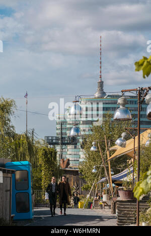 BERLIN, ALLEMAGNE - 26 septembre 2018 : point de vue vers le haut contraste des filles marcher parmi un environnement naturel à l'Holzmarkt, avec le célèbre Banque D'Images