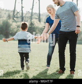 Une famille avec de jeunes fils jouant dans un parc ; Edmonton, Alberta, Canada Banque D'Images