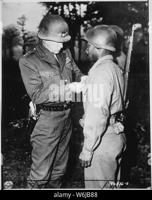 Le lieutenant-général George S. Patton, commandant de l'armée américaine troisième, les broches le Silver Star sur le Soldat Ernest A. Jenkins, de la ville de New York pour sa bravoure à la libération de Châteaudun, en France..., 10/13/1944 Banque D'Images