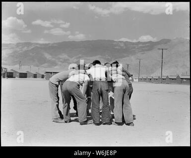 Manzanar Manzanar, Centre de réinstallation, en Californie. Les joueurs de baseball au cours d'un échange. Ce jeu est très . . . ; Portée et contenu : la légende complète pour cette photographie se lit comme suit : Manzanar Manzanar, Centre de réinstallation, en Californie. Les joueurs de baseball au cours d'un échange. Ce jeu est très populaire auprès des 80 équipes ayant été formés à ce jour. La plupart de la lecture se fait dans le coupe-feu large entre les blocs de casernes. Banque D'Images