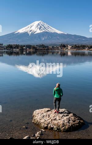 Jeune femme debout sur la pierre dans l'eau, le lac Kawaguchi, volcan retour Mt. Fuji, préfecture de Yamanashi, Japon Banque D'Images