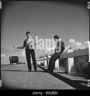 Oakland, Californie. De l'autostop. Un travail professionnel de se moquer. Ces deux garçons voyager ensemble d'un chantier à l'autre dans l'Ouest. L'attention de l'thumber costume avec chemise propre, collegiate veste et des chaussures cirées, est un classique comme la limite de la ville. Ces garçons ont dit que leur ambition était de s'installer à un emploi stable, de préférence service civil Banque D'Images