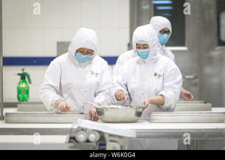 Les travailleurs chinois préparer des brioches à la vapeur sur la ligne de production à une usine de transformation des aliments de la Beijing Jingtie Service Co., Ltd. à Beijing, Chine, 7 Banque D'Images