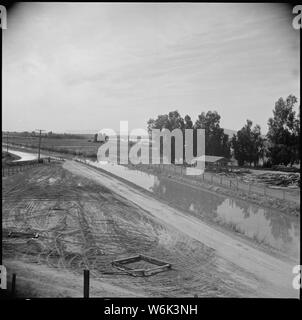 Poston, Arizona. Au premier plan on peut voir le canal d'irrigation qui fournira à l'aide d'une . Poston . . ; Portée et contenu : la légende complète pour cette photographie se lit comme suit : Poston, Arizona. Au premier plan on peut voir le canal d'irrigation qui fournira de l'eau agricole avec Poston. Ce canal reçoit son eau du barrage Parker. Dans l'arrière-plan, on peut voir le fleuve Colorado. Banque D'Images