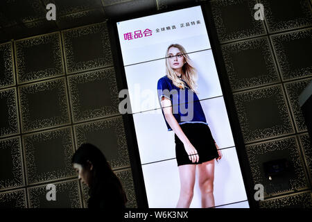 --FILE--un piéton passe devant une publicité pour le détaillant de mode en ligne chinois de Vipshop vip.com Holdings Ltd. dans la ville de Guangzhou, Chine du sud. Banque D'Images