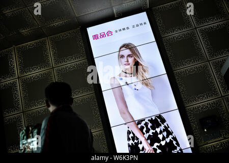 --FILE--un piéton passe devant une publicité pour le détaillant de mode en ligne chinois de Vipshop vip.com Holdings Ltd. dans la ville de Guangzhou, Chine du sud. Banque D'Images