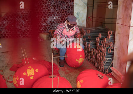 Un travailleur chinois fait des lampions rouges pour la prochaine fête du printemps ou le Nouvel An Chinois (année du Chien) d'une usine à Miluo ville, Yueyang cit Banque D'Images