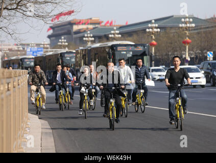 --FILE--cyclistes la bicyclette de vélo-partage des services chinois Ofo sur l'Avenue Chang'an à Beijing, Chine, 10 mars 2017. Les utilisateurs de vélo partagé en Chine Banque D'Images