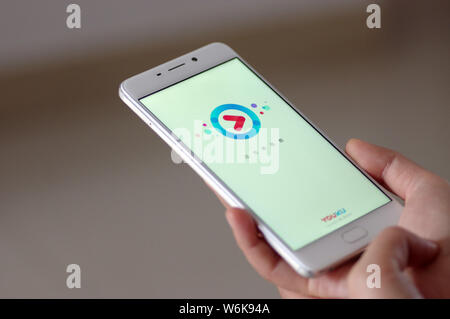 --FILE--un résident chinois local utilise l'application mobile du site de vidéo en ligne Youku.com, une filiale du géant de l'e-commerce chinois Alibaba Group, sur sa sm Banque D'Images