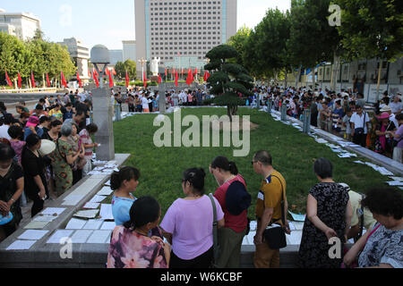 --FILE--parents chinois regarder et prendre des photos de renseignements personnels de personnes non mariées pendant un événement de jumelage à Shijiazhuang, Chine du nord Banque D'Images