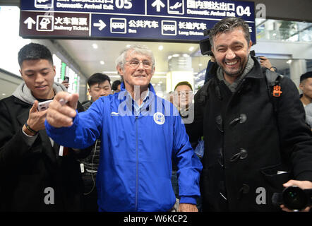 Entraîneur de football serbe et ancien joueur Bora Milutinovic, centre, est entouré de fans comme il arrive à l'aéroport international Chengdu Shuangliu Banque D'Images