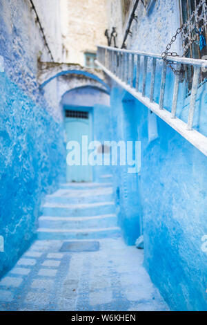 (Selective focus) avec une vue magnifique sur une ruelle étroite avec la substitution, bleu bâtiments blanchis à la chaux. Banque D'Images