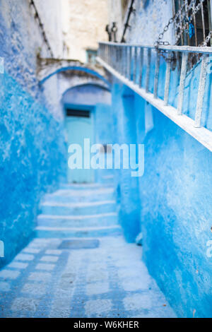 (Selective focus) avec une vue magnifique sur une ruelle étroite avec la substitution, bleu bâtiments blanchis à la chaux. Banque D'Images