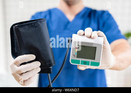 Médecin cardiologue détient le contrôle de pression, l'appareil en main. tonomètre Objet médical. Banque D'Images