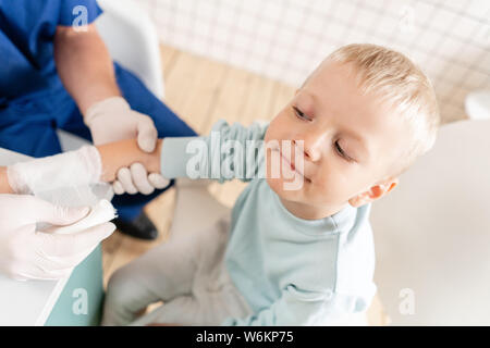 Une main bandée médecin garçon avec des traumatismes dans son bras. Un bandage élastique autour de sa main Banque D'Images