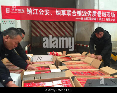 Les agents de police chinois vérifier 2 333 cartouches de cigarettes de marque Zhonghua contrefaits saisis lors d'une opération d'hiver à Zhenjiang city, est de la Chine. Banque D'Images