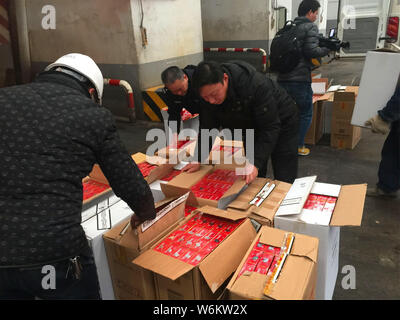 Les agents de police chinois vérifier 2 333 cartouches de cigarettes de marque Zhonghua contrefaits saisis lors d'une opération d'hiver à Zhenjiang city, est de la Chine. Banque D'Images