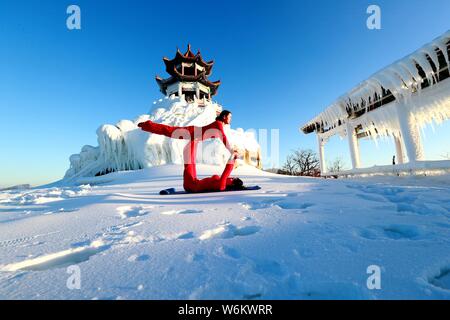 Filles en portant des vêtements de yoga Yoga effectuer contre le froid à un ski park dans le comté de Luanchuan, Luoyang city, province du Henan en Chine centrale, 11 J Banque D'Images