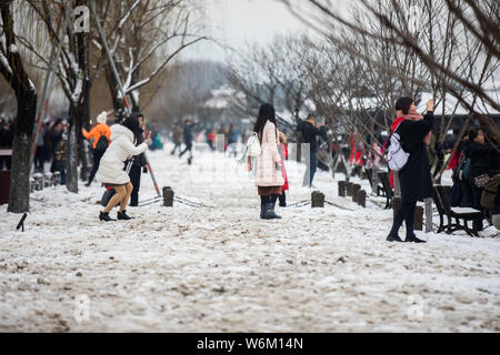 Les touristes l'étape sur la pelouse pour prendre des photos au lac de l'Ouest dans la zone panoramique de la ville de Hangzhou, Zhejiang Province de Chine orientale, le 28 janvier 2018. Banque D'Images