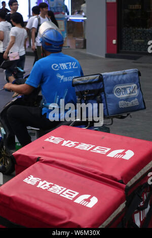 --FILE--un livreur de l'entreprise de livraison de repas chinois Ele.me rides passé triporteurs de livraison de nourriture en ligne chinois Baidu Waimai entreprise, la nourriture deliv Banque D'Images