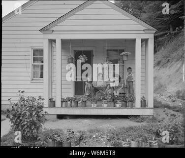 T. J. Martin, mineur, et de la famille sur le porche avant de leur maison. M. Martin est arrivé ici il y a 13 mois. A économisé assez d'argent pour retourner à Floyd County, New York., où il sera de nouveau sur sa propre ferme. Koppers Division du charbon, Kopperston Kopperston, Mines, Wyoming County, Virginie occidentale. Banque D'Images