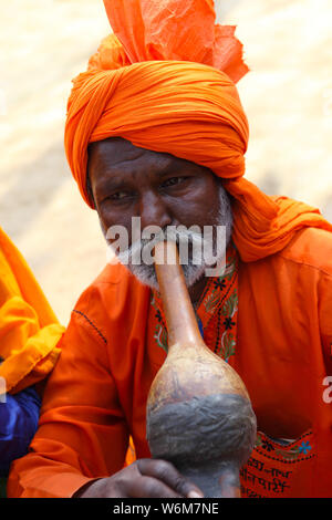 Snake charmer playing pungi at Surajkund Crafts Mela, Surajkund, Faridabad, Haryana, India Stock Photo