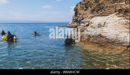 Groupe de plongeurs sous-prêt pour la plongée dans la belle Grèce mer turquoise. Des vacances d'activité. Banque D'Images