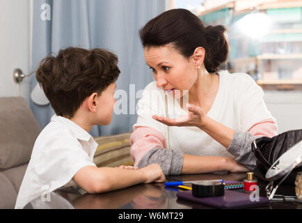 Discuter avec les débordements de mère agacée tween fils tout en restant assis à la maison le tableau Banque D'Images