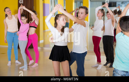 Groupe de pratique d'interpolations de mouvements vigoureux jive en classe de danse avec entraîneur féminin Banque D'Images