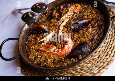 Paella Valencienne marinera savoureux avec des moules et des crevettes servi sur pan traditionnels en métal Banque D'Images