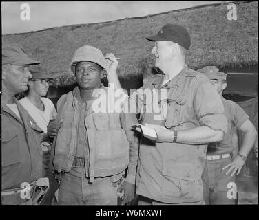 Le Vietnam. John Wayne signe le soldat de première classe Fonsell Wofford's casque lors de sa visite à la 3e Bataillon, 7e Marines, au chu Lai.. Banque D'Images