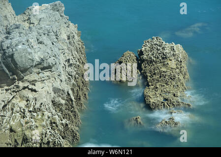 Clapotis des vagues autour des roches dans les eaux bleu turquoise de la mer, sur la magnifique côte rocheuse de Pembrokeshire, Pays de Galles Banque D'Images