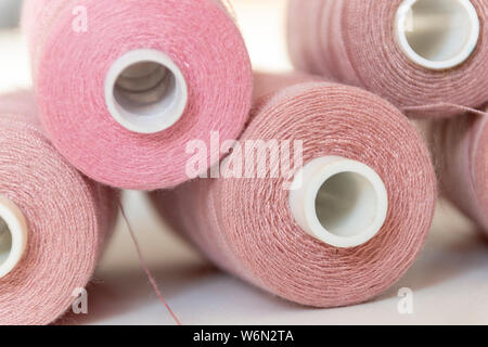 Une vue rapprochée de cinq bobines de coton rose dans une pile sur un fond isolé Banque D'Images