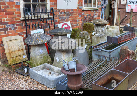 Staddle pierres et d'ornements de jardin en pierre d'époque sur l'affichage dans la cour d'une boutique d'antiquités à Hungerford, un marché de la ville historique de Berkshire, Royaume-Uni Banque D'Images