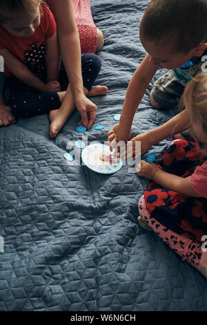 Les enfants d'apprendre à lire l'heure de réveil et de mettre les mains dans la position correcte. Les enfants d'âge préscolaire Enseignement lire l'heure. Les gens sincères, vrais moments, aut Banque D'Images