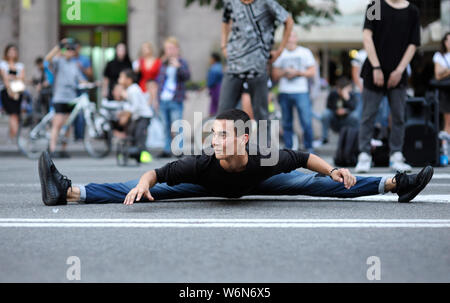 Jeune danseur de rue dans la rue, faisant pleine split. Le 3 juillet 2019. Kiev, Ukraine Banque D'Images