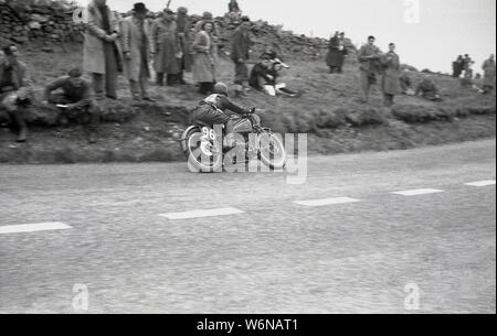 Années 1950, historique, un motocycliste équitation dans la course TT sur l'île de Man. Le célèbre TT (Tourist Trophy) courses de moto begain en 1907 et ont lieu sur la voie publique de l'île, sur le Sneffels Mountain bien sûr, même si entre 1954-1959, les courses sont sur le Cylpse avec grille de cours complète traditionnelle commence. Banque D'Images