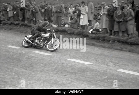 Années 1950, historique, un motocycliste équitation dans la course TT sur l'île de Man. Le célèbre TT (Tourist Trophy) courses de moto begain en 1907 et ont lieu sur la voie publique de l'île, sur le Sneffels Mountain bien sûr, même si entre 1954-1959, les courses sont sur le Cylpse avec grille de cours complète traditionnelle commence. Banque D'Images