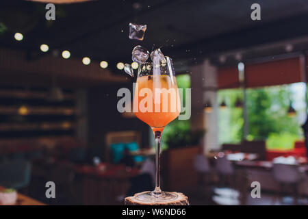 Des cubes de glace tomber dans un cocktail d'orange d'éclaboussures. Banque D'Images