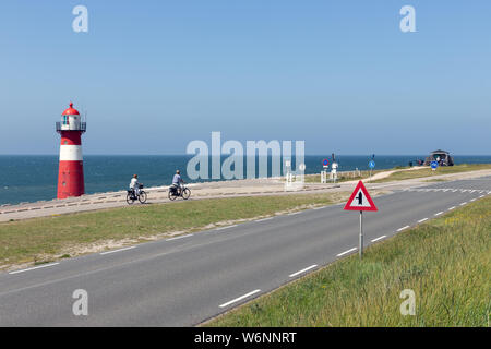 Phare de la digue avec les motards de passage près de Westkapelle, les Pays-Bas Banque D'Images