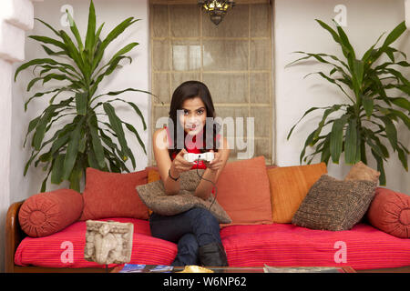 Young woman playing video game at home Banque D'Images