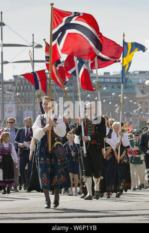 Norwegian national drapeaux flottant au cours d'un défilé patriotique passant par Ostermalmstorg, vers Skansen pour assister à la journée de l'indépendance de chaque année. La Suède Banque D'Images