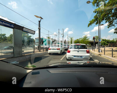 Villeneuve-la-Garenne, Paris, France - Jul 15, 2018 : La vue de la voiture de métro RER train arrivant en gare et des voitures à attendre au rond-point rouge en France Banque D'Images