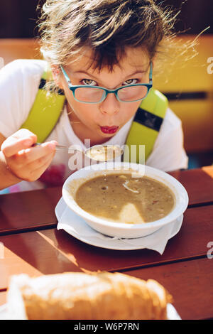 Petite fille dans les verres de manger de la soupe Banque D'Images