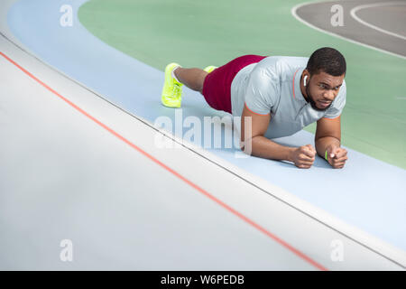 Athlète masculin motivés de faire un exercice de base plank Banque D'Images