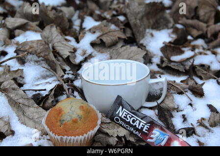 Tasse de Nescafé froid en hiver avec la neige tasse de café et gâteau pause par temps froid le café potable feuilles autour de Snowy White snow Nescafe Banque D'Images