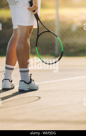 Cropped shot de sportif, avec la raquette sur un court de tennis. Un joueur de tennis sur surface dure de base. Banque D'Images