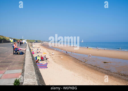 L'été au bord de la mer où les familles profitez d'une journée ensoleillée sur la longue plage de sable sur la côte Nord à Tyneside Whitley Bay dans la région de Tyne et Wear Banque D'Images